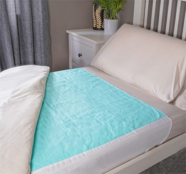 wasbare bedpads met instopstroken die op een bed ligt met het laken er half overheen