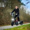Joiny driewieler met verlichting op een fietspad tussen de bomen