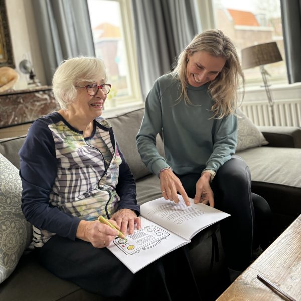 Foto van mensen die in het boek kleuren